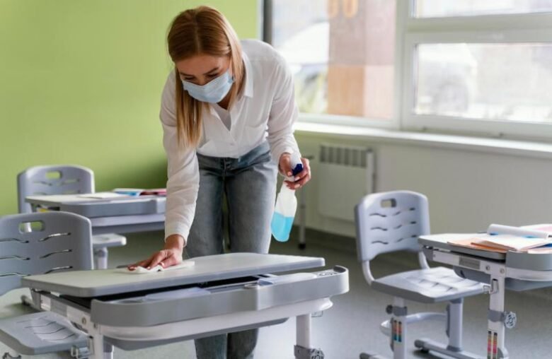 front-view-female-teacher-disinfecting-school-benches-classroom (2) (1)