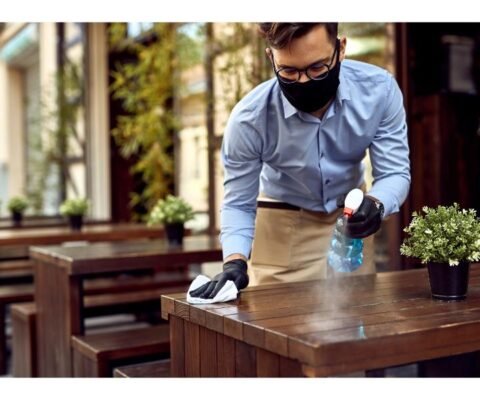 waiter-wearing-protective-face-mask-while-disinfecting-tables-outdoor-cafe (1)