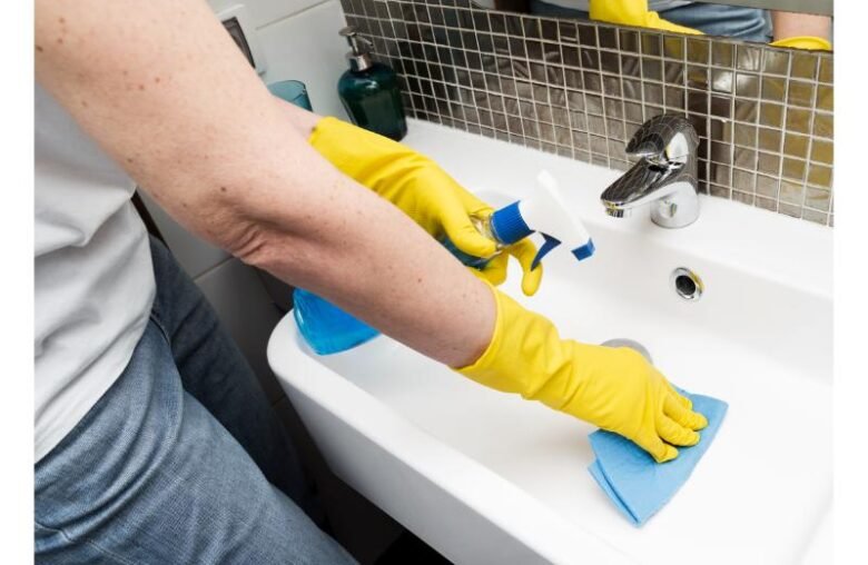 woman-with-rubber-gloves-cleaning-sink (1)